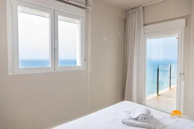 a bedroom with a bed and a window with the ocean at Malibu by Cadiz Time in Cádiz