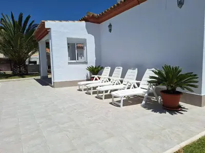 a group of white chairs sitting on a patio at Charming villa in Chiclana de la Frontera with private pool in Chiclana de la Frontera
