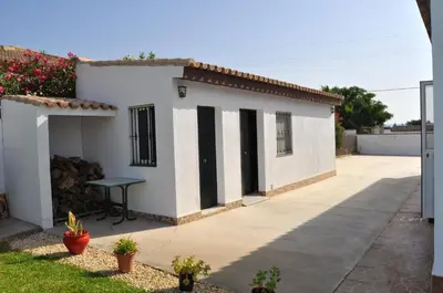 a small white house with a green table outside at Charming villa in Chiclana de la Frontera with private pool in Chiclana de la Frontera