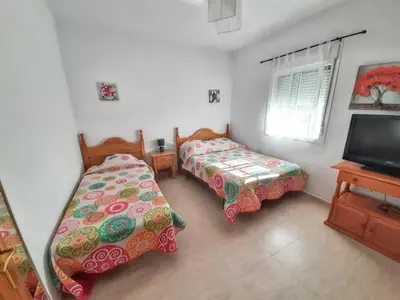 a bedroom with two beds and a flat screen tv at Charming villa in Chiclana de la Frontera with private pool in Chiclana de la Frontera