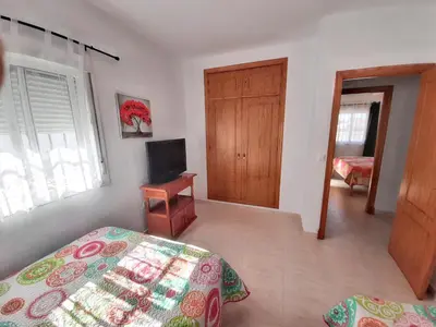 a bedroom with a bed and a television in it at Charming villa in Chiclana de la Frontera with private pool in Chiclana de la Frontera
