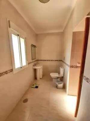 a bathroom with a toilet and a sink and a window at Charming villa in Chiclana de la Frontera with private pool in Chiclana de la Frontera
