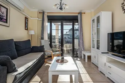 a living room with a couch and a tv at Apartamento familiar muy soleado cerca de la playa y parking incluido in Chiclana de la Frontera