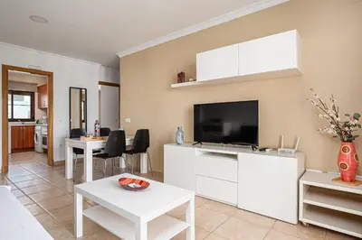a living room with a flat screen tv on the wall at Apartamento familiar muy soleado cerca de la playa y parking incluido in Chiclana de la Frontera