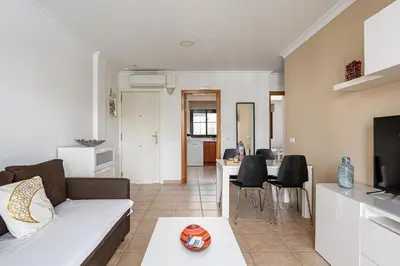 a living room with a couch and a table at Apartamento familiar muy soleado cerca de la playa y parking incluido in Chiclana de la Frontera