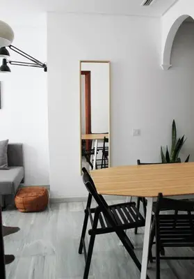 a living room with a wooden table and chairs at Enjoy the historic center of Chiclana By C. Dreams in Chiclana de la Frontera