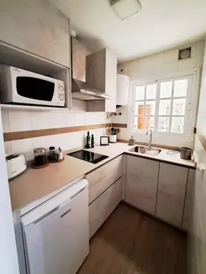 a small kitchen with a sink and a microwave at Enjoy the historic center of Chiclana By C. Dreams in Chiclana de la Frontera