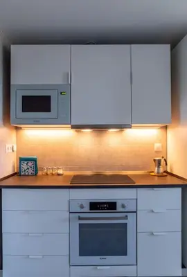 a kitchen with white cabinets and a microwave at El Beduino by Gades Gestión in Cádiz