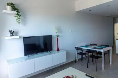 a living room with a television and a table with chairs at El Beduino by Gades Gestión in Cádiz
