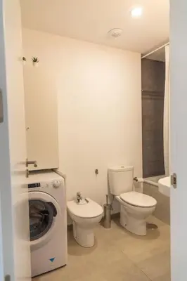 a bathroom with a toilet and a washing machine at El Beduino by Gades Gestión in Cádiz