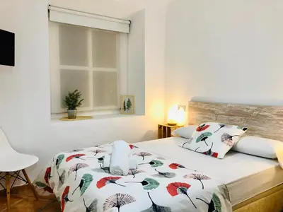 a bedroom with a bed with a comforter on it at Pensión La Cantarera in Cádiz
