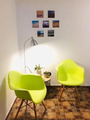 two green chairs in a room with a table at Pensión La Cantarera in Cádiz