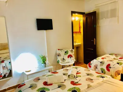 a hotel room with two beds and a mirror at Pensión La Cantarera in Cádiz