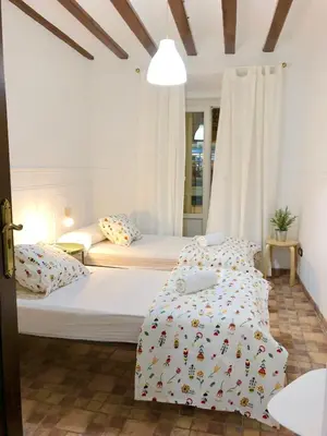 two beds in a small room with white walls at Pensión La Cantarera in Cádiz