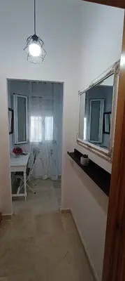 a living room with a mirror and a table at Apartamento Pale Cream in Jerez de la Frontera