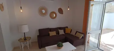 a living room with a brown couch and a table at Apartamento Pale Cream in Jerez de la Frontera