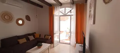 a living room with a couch and a glass door at Apartamento Pale Cream in Jerez de la Frontera