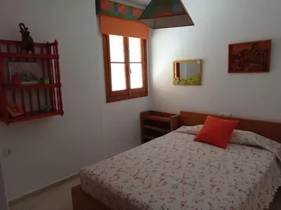 a bedroom with a bed with two towels on it at Cruces, piso en pleno centro urbano in Sanlúcar de Barrameda