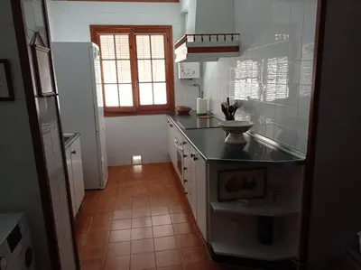 a kitchen with a counter top and a refrigerator at Cruces, piso en pleno centro urbano in Sanlúcar de Barrameda