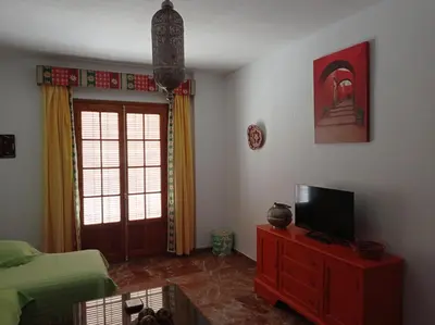 a living room with a television on a wooden dresser at Cruces, piso en pleno centro urbano in Sanlúcar de Barrameda