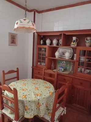 a kitchen with a table and chairs and a chandelier at Cruces, piso en pleno centro urbano in Sanlúcar de Barrameda