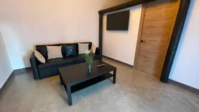 a living room with a black couch and a table at Casa del lago in Sanlúcar de Barrameda
