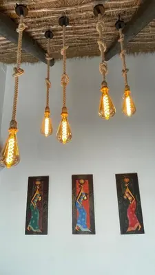a group of lights hanging from a wall with paintings at Casa del lago in Sanlúcar de Barrameda