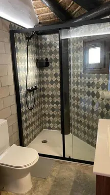 a bathroom with a glass shower with a toilet at Casa del lago in Sanlúcar de Barrameda