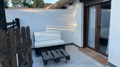 a bench sitting on a patio next to a window at Casa del lago in Sanlúcar de Barrameda
