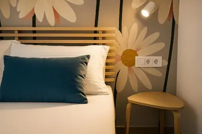 a bed with a blue pillow and a chair in a room at Skyline - Beach apartment with breathtaking views and more in Cádiz