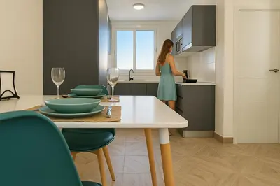 a woman standing in a kitchen looking out the window at Skyline - Beach apartment with breathtaking views and more in Cádiz