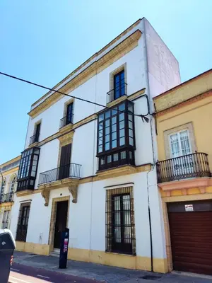 a white building with black windows on a street at Porvenir centro in Jerez de la Frontera