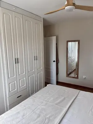a bedroom with a bed with a ceiling fan and a mirror at Apartamento en primera línea de playa Valdemar 1 in El Puerto de Santa María