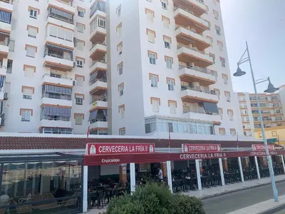a building with a restaurant in front of a building at Apartamento en primera línea de playa Valdemar 1 in El Puerto de Santa María
