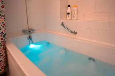 a bath tub filled with blue water in a bathroom at Cielo gaditano in Cádiz