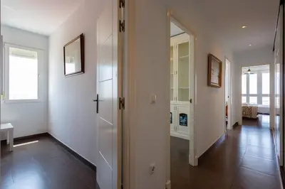 a hallway with white walls and a hallway with a door at Cielo gaditano in Cádiz