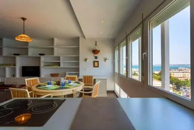 a kitchen and dining room with a table and some windows at Cielo gaditano in Cádiz