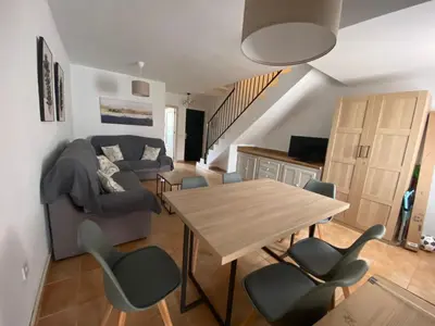 a living room with a couch and a table and chairs at Apartamento La Balconera 1ª línea de Playa in Chiclana de la Frontera