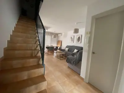 a living room with a staircase and a couch at Apartamento La Balconera 1ª línea de Playa in Chiclana de la Frontera
