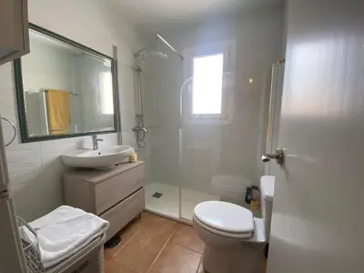 a bathroom with a toilet and a sink and a shower at Apartamento La Balconera 1ª línea de Playa in Chiclana de la Frontera