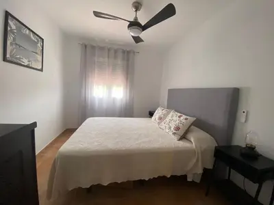a bedroom with a bed with a ceiling fan at Apartamento La Balconera 1ª línea de Playa in Chiclana de la Frontera