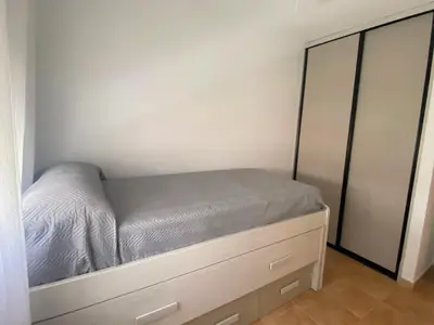 a small bedroom with a bed and a dresser at Apartamento La Balconera 1ª línea de Playa in Chiclana de la Frontera