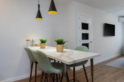 a dining room with a white table and chairs at Apartoyou - Enamorados in El Puerto de Santa María