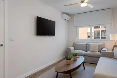 a living room with a couch and a flat screen tv at Apartoyou - Enamorados in El Puerto de Santa María