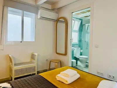 a bathroom with a bed and a mirror and a toilet at La Botica Grupo AC Gestion in Cádiz