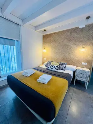 a bedroom with a large bed and a desk at La Botica Grupo AC Gestion in Cádiz