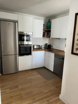 a kitchen with white cabinets and stainless steel appliances at Villa en Urbanización Ciudad Ducal in El Puerto de Santa María