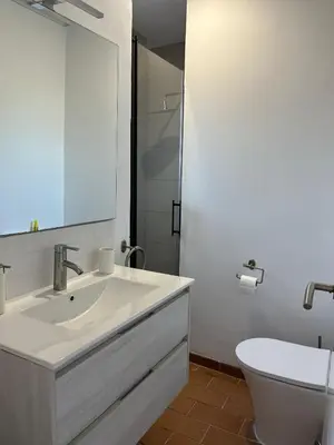 a white bathroom with a sink and a toilet at Villa en Urbanización Ciudad Ducal in El Puerto de Santa María