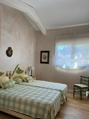 a bedroom with a bed with a plaid blanket and a window at Villa en Urbanización Ciudad Ducal in El Puerto de Santa María