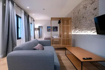 a living room with a blue couch and a table at VILLAR Suites by Cadiz4Rentals in Cádiz